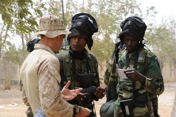   A United States Marine adviser speaks with the leaders of an African special forces unit during a training exercise. (Master Sgt. Jeremiah Erickson/U.S. Air Force Photo)  
